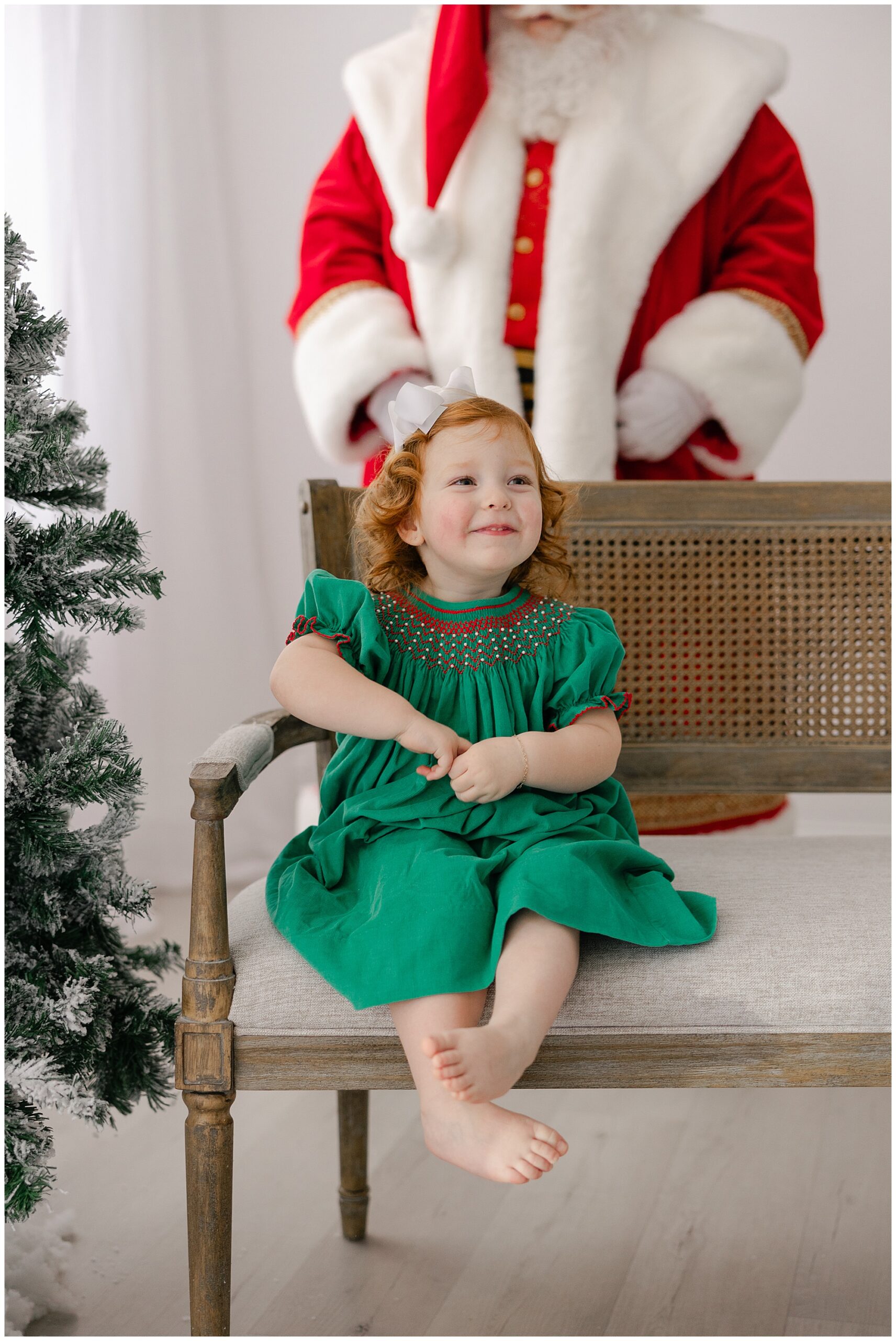 child sitting on bench with santa behind