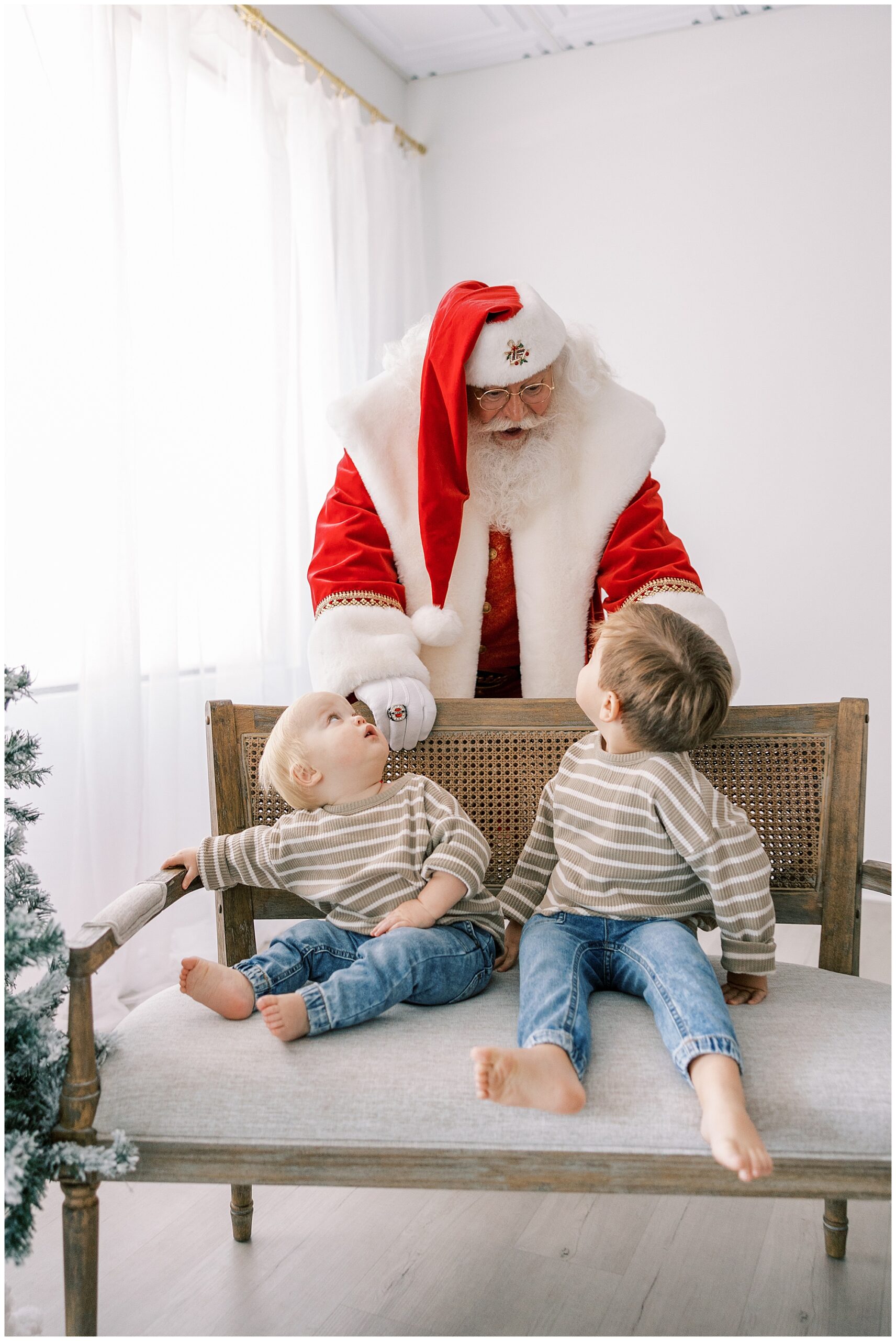 two brothers looking up at Santa on bench