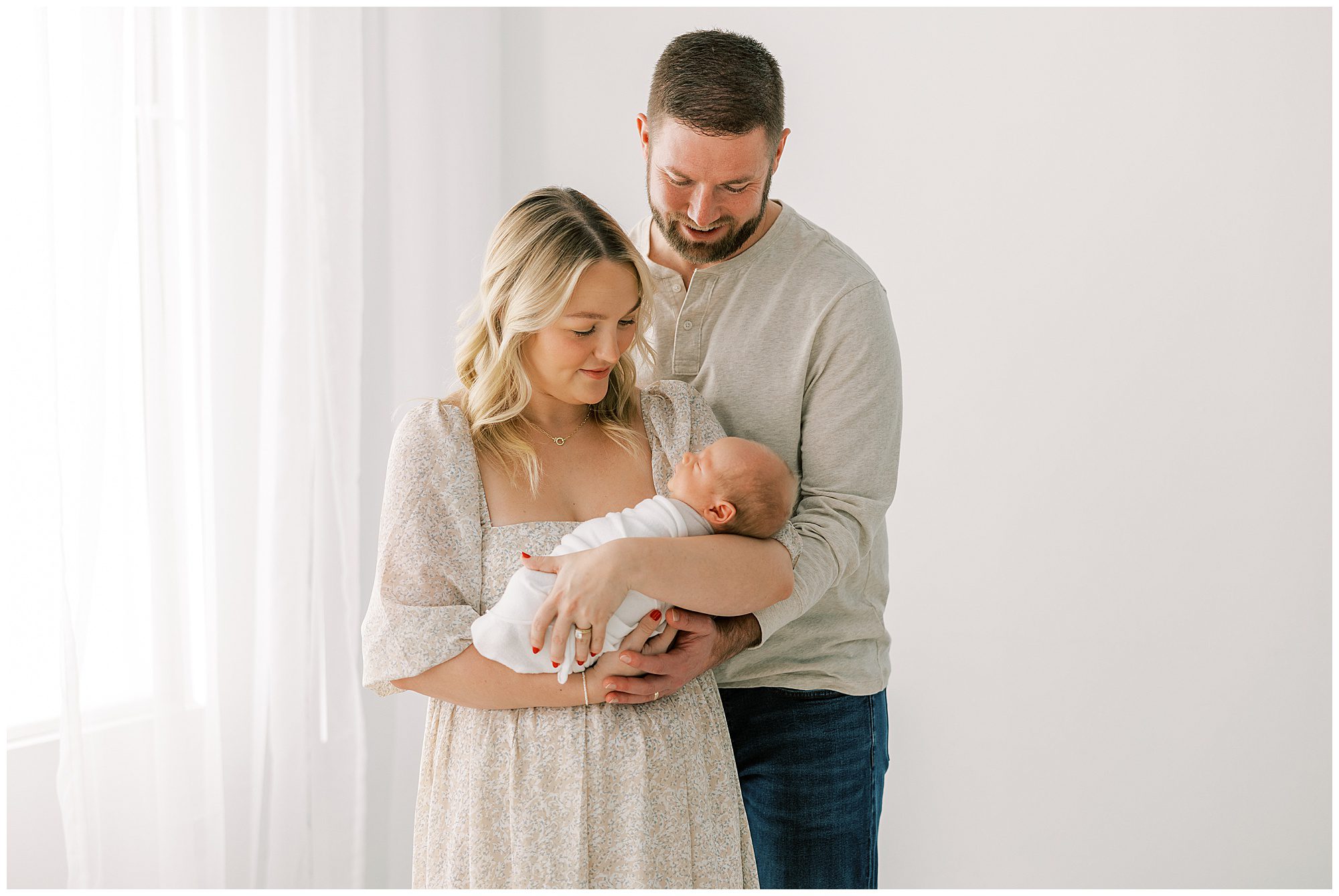 mom and dad holding a sleeping baby at knoxville newborn session