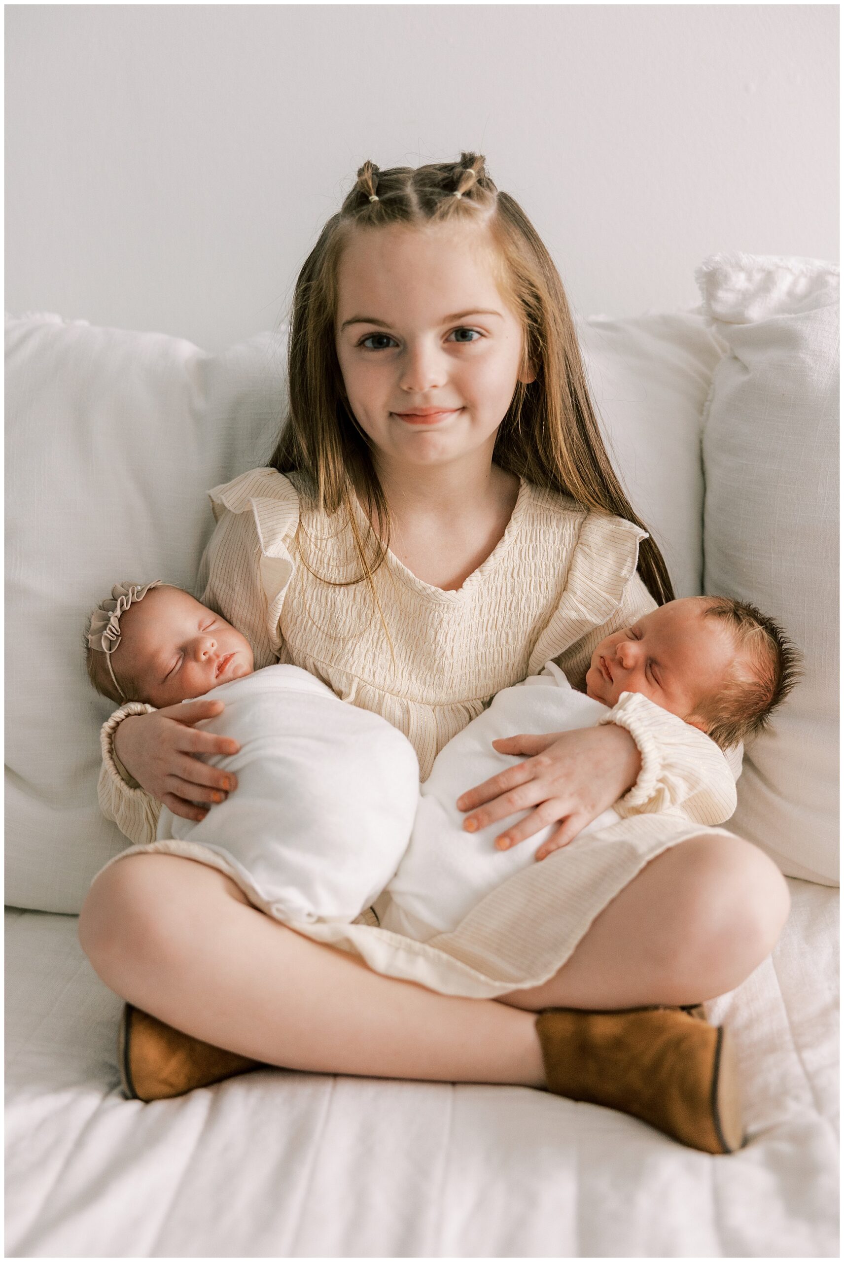 older sister holding baby brother and sister
