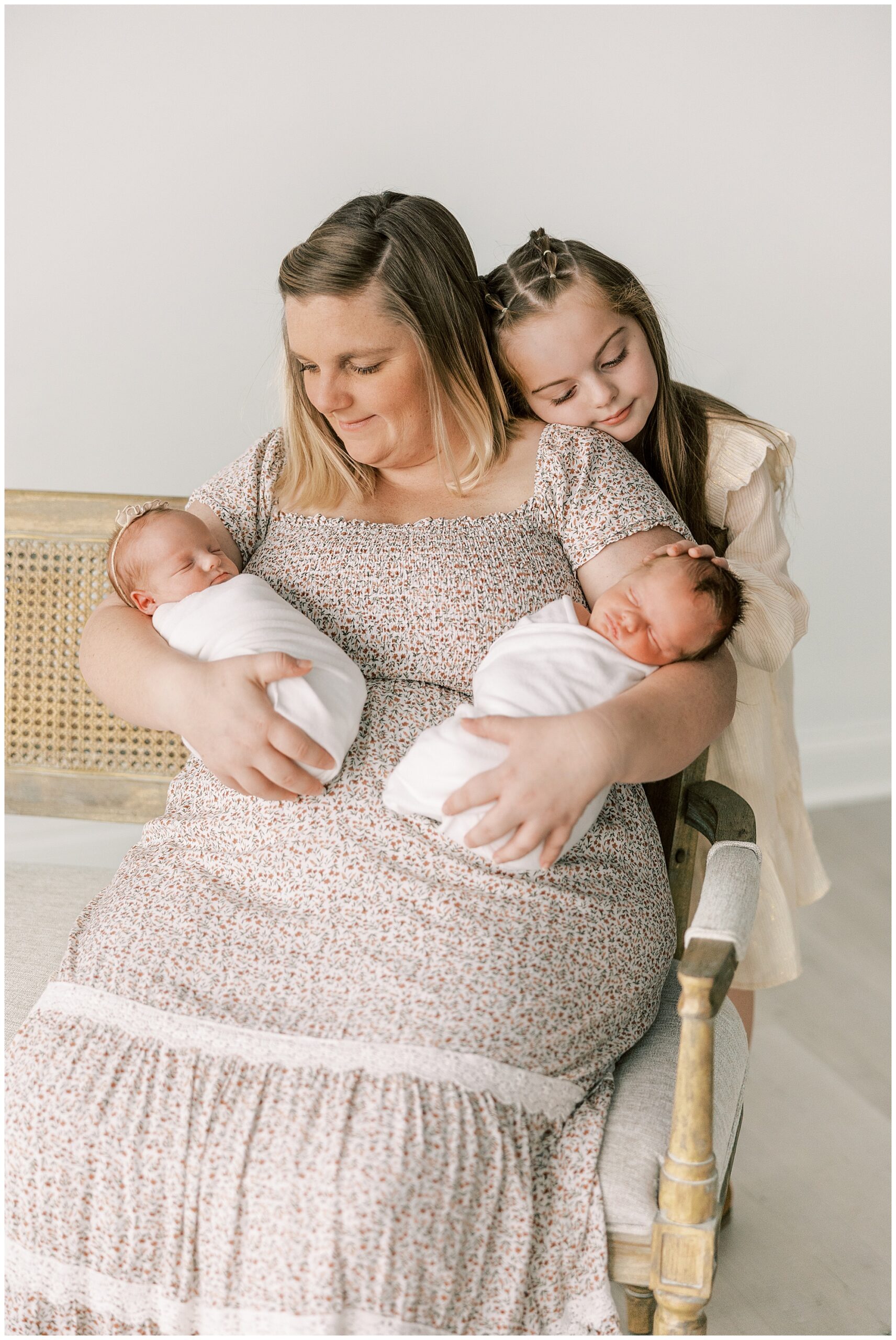 mom holding twin newborn babies