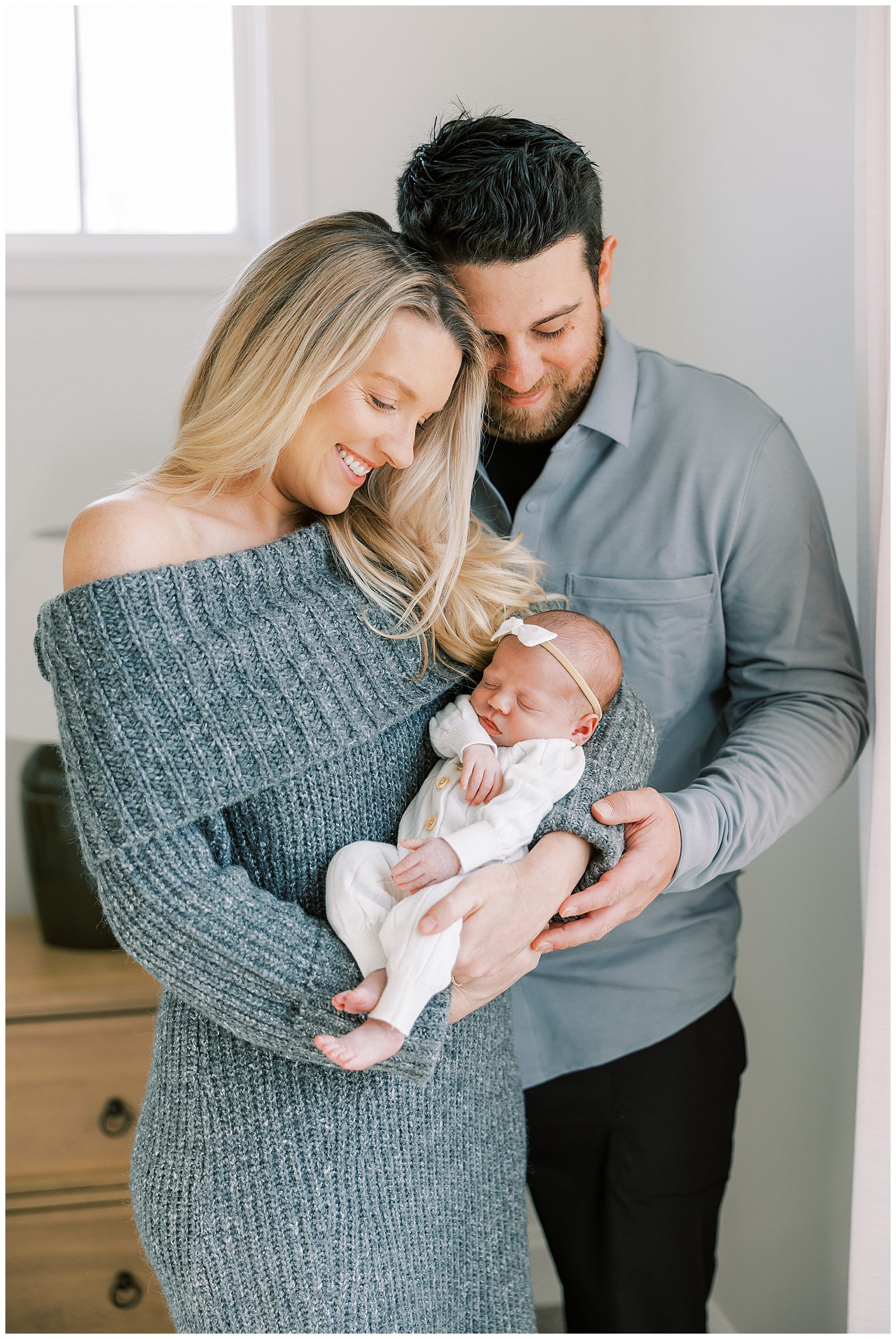 mom and dad holding baby at in home newborn session