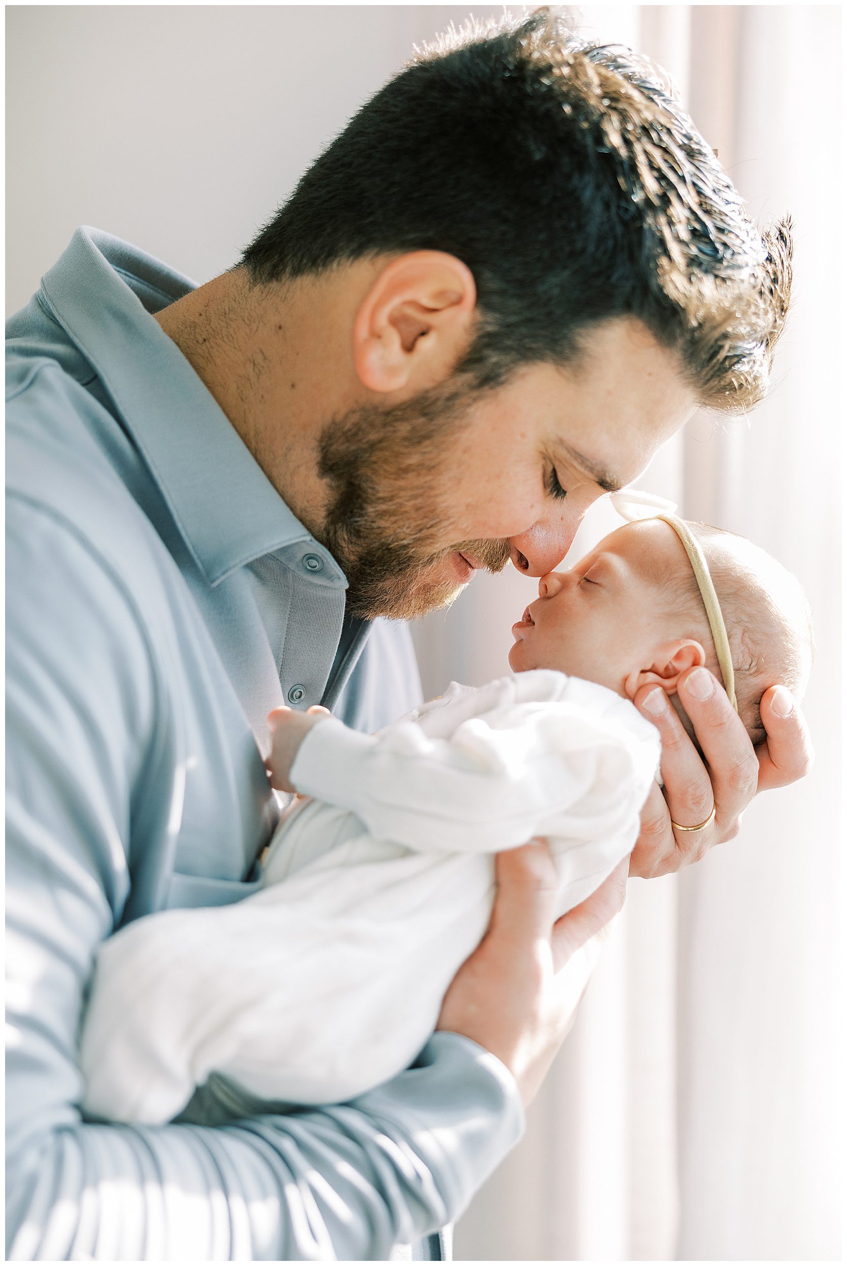 dad touching noses with newborn baby girl