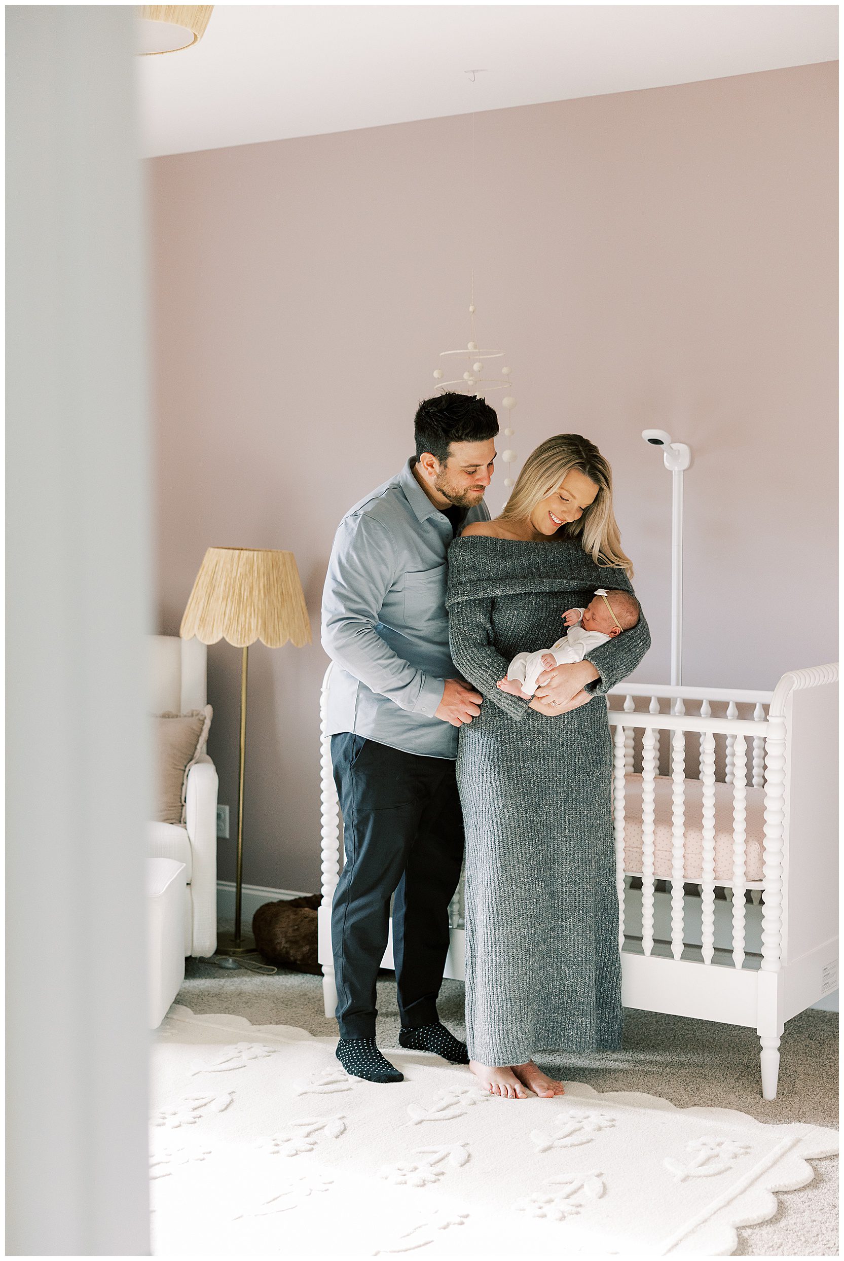 mom and dad standing in baby's nursery