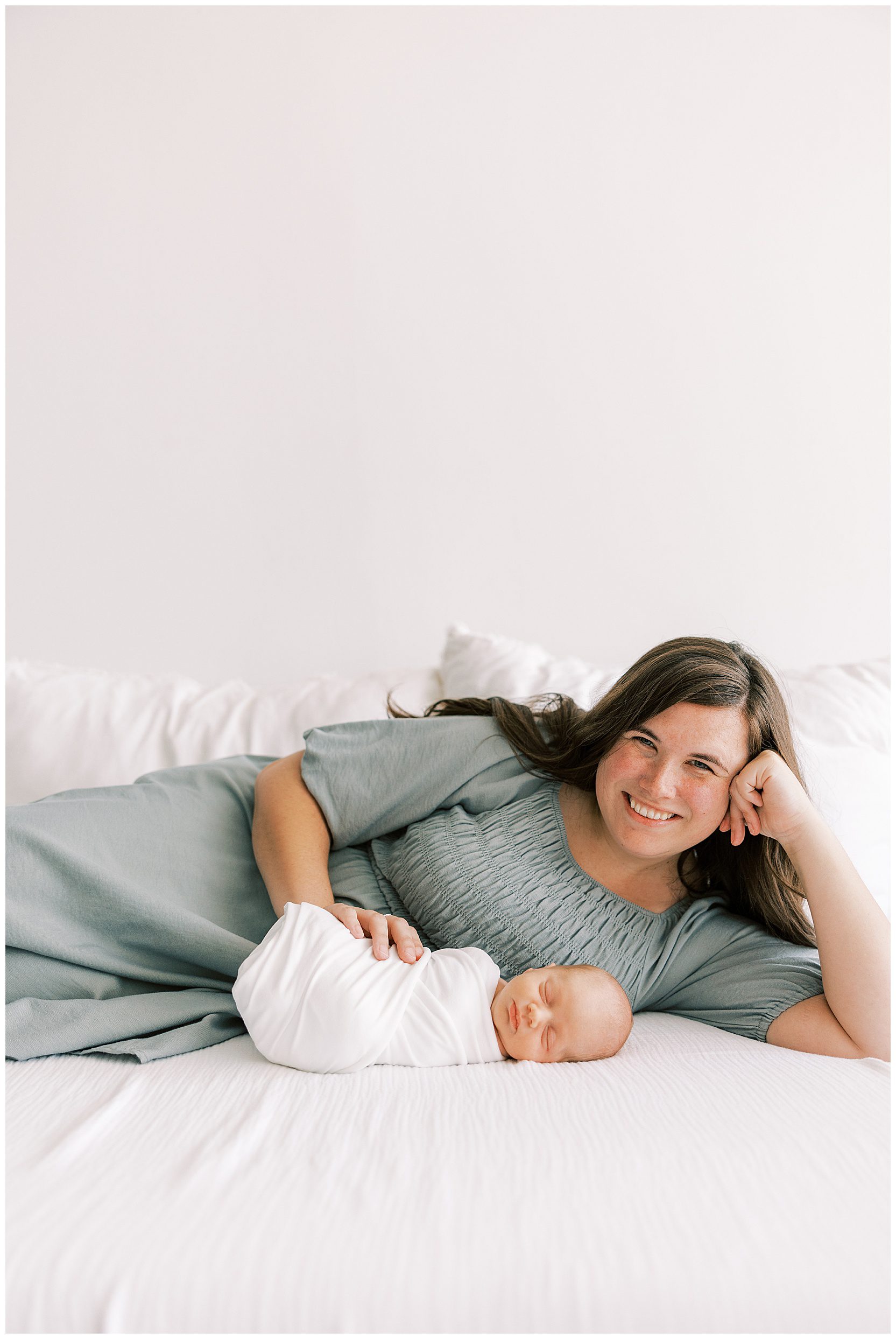 mom laying on bed with new baby