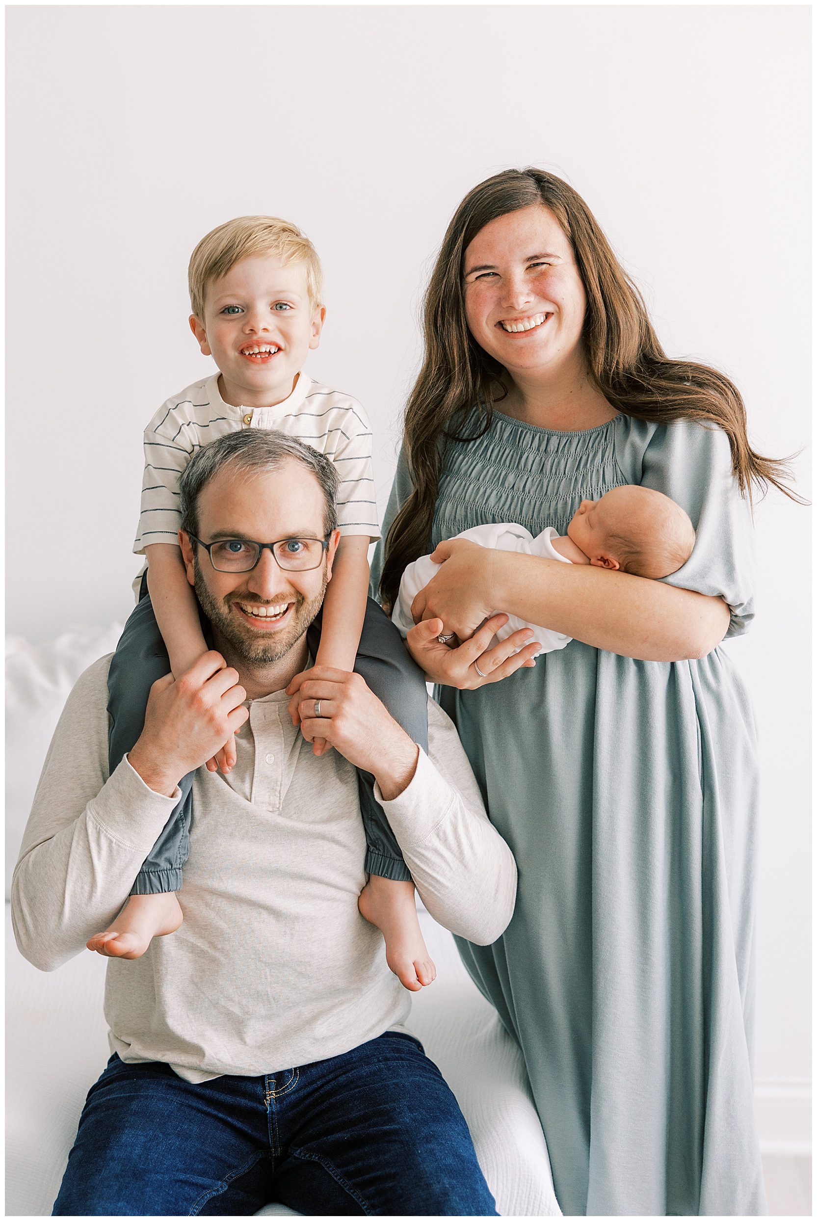 whole family smiling at camera at newborn session