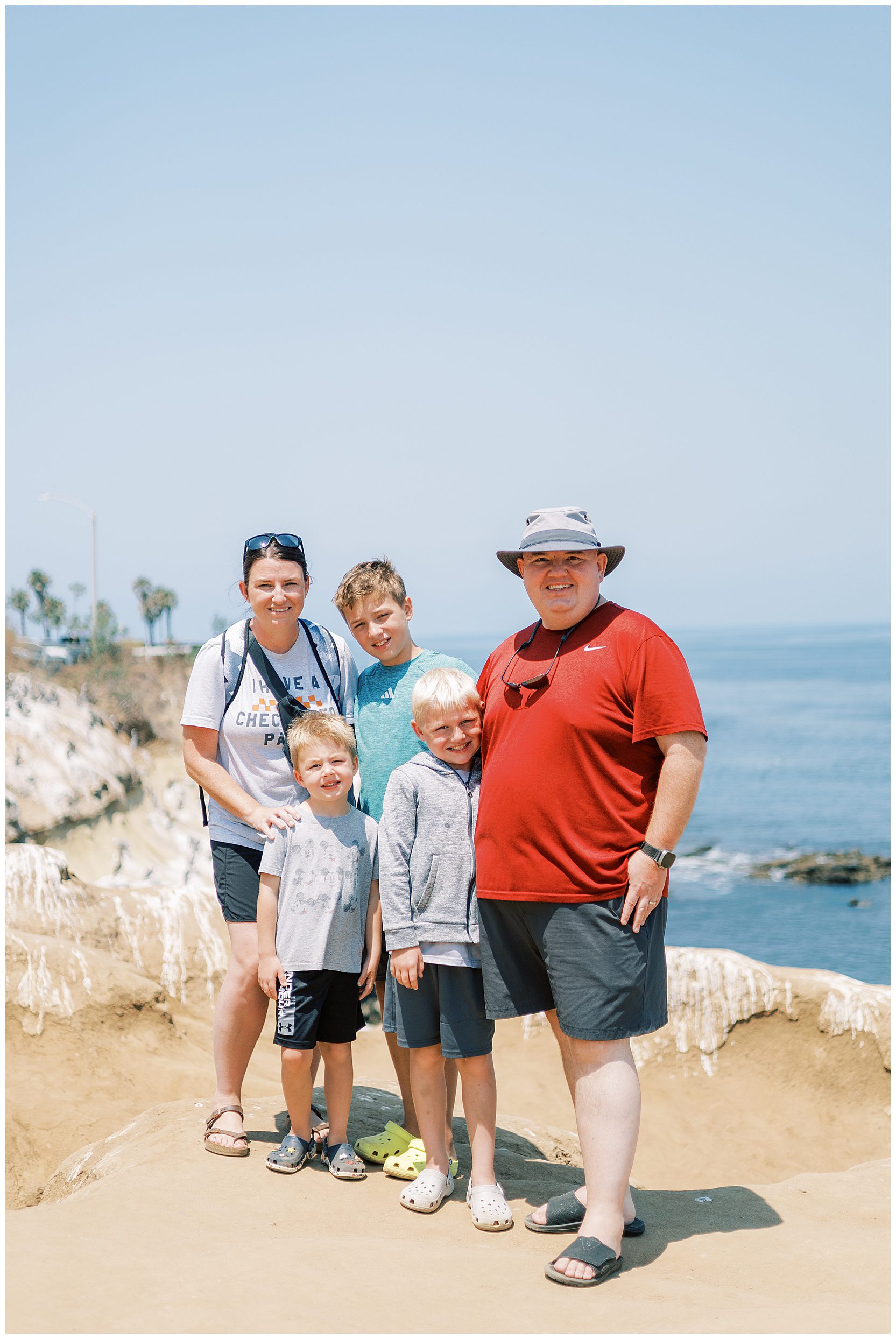 whole family posing in front of ocean