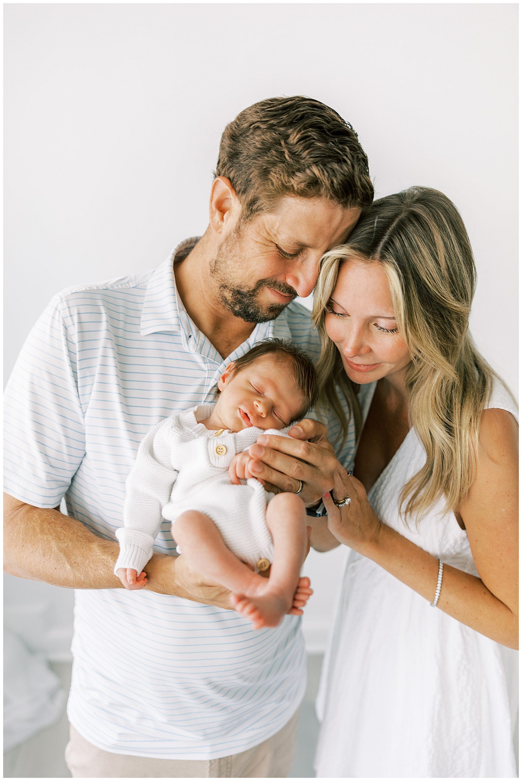 mom and dad holding sleeping baby boy