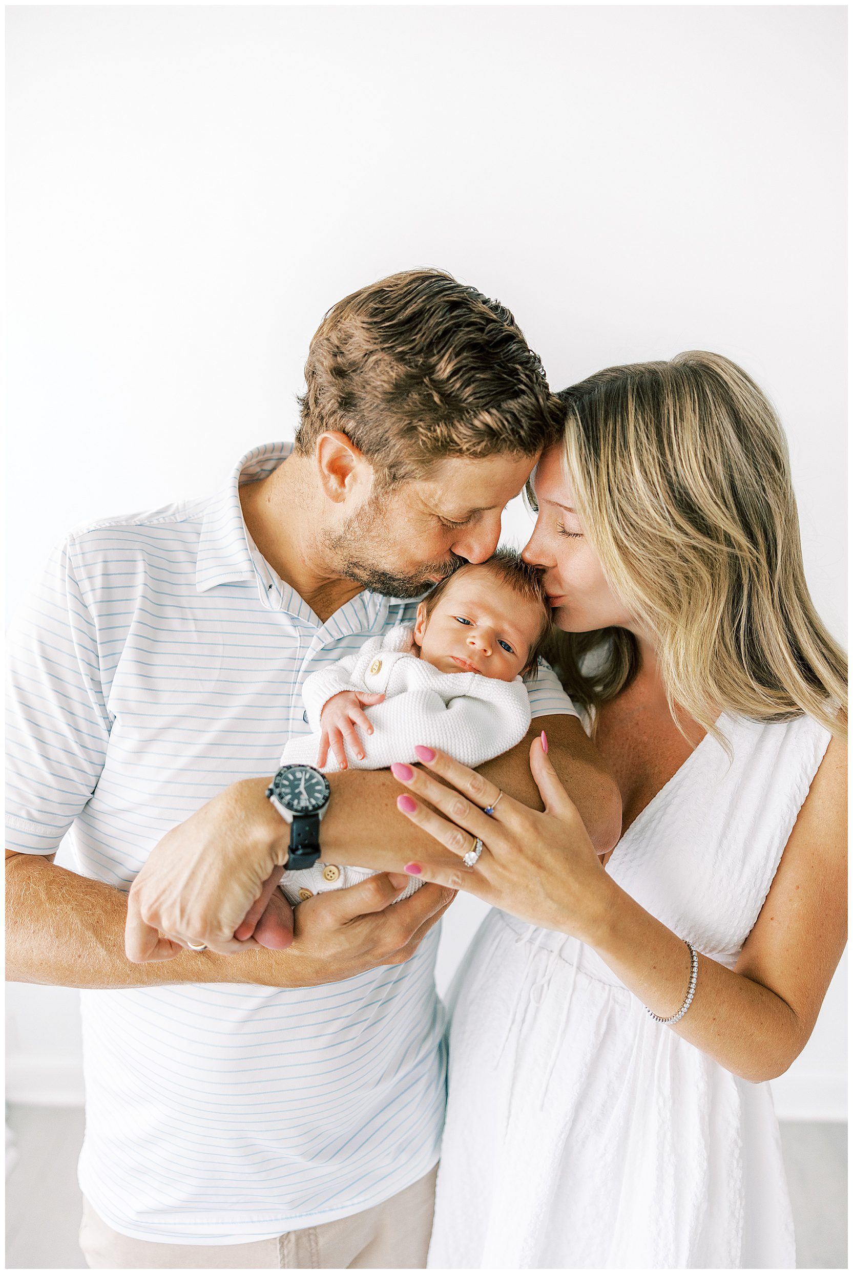 mom and dad holding sleeping baby boy