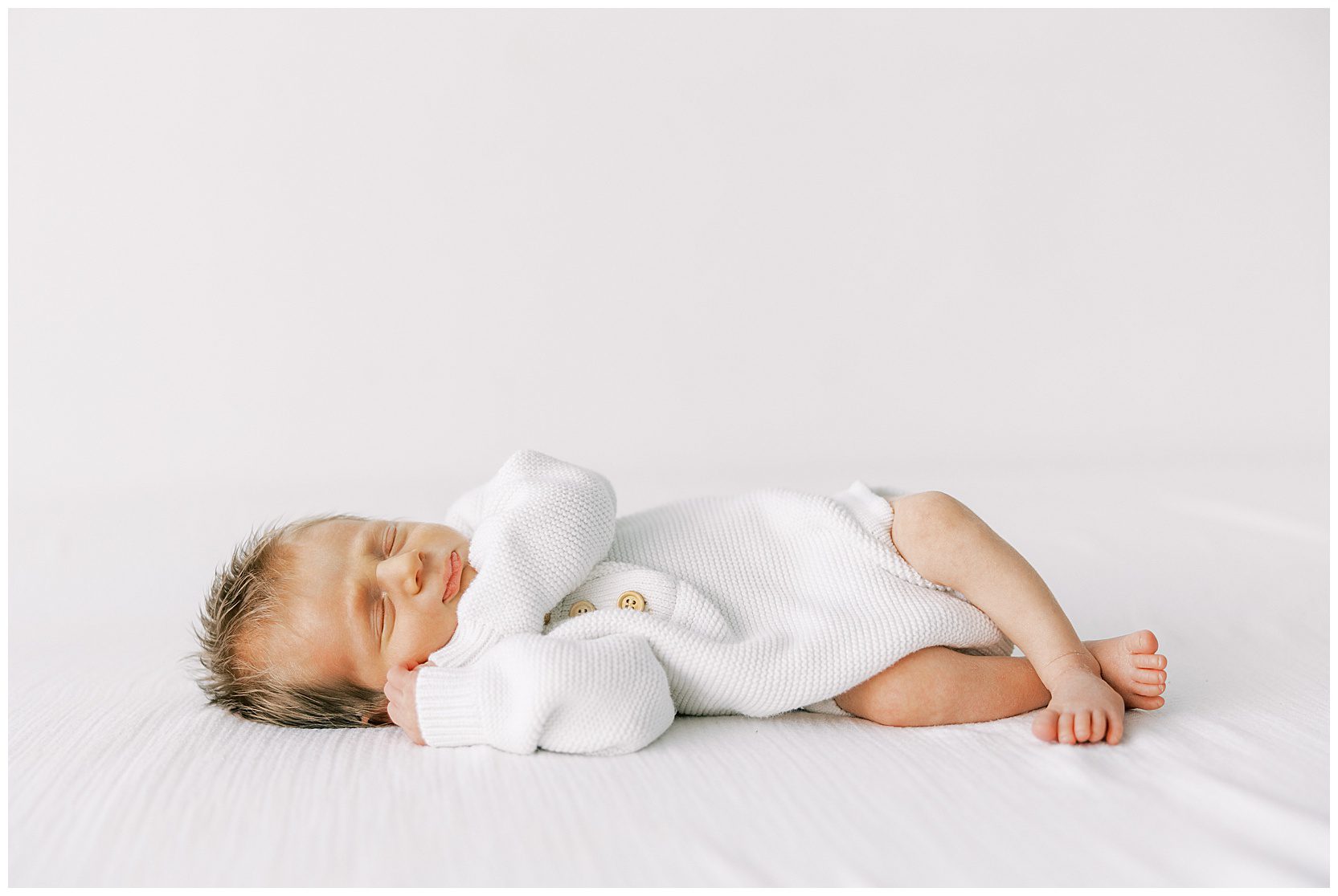baby sleeping on bed at newborn session