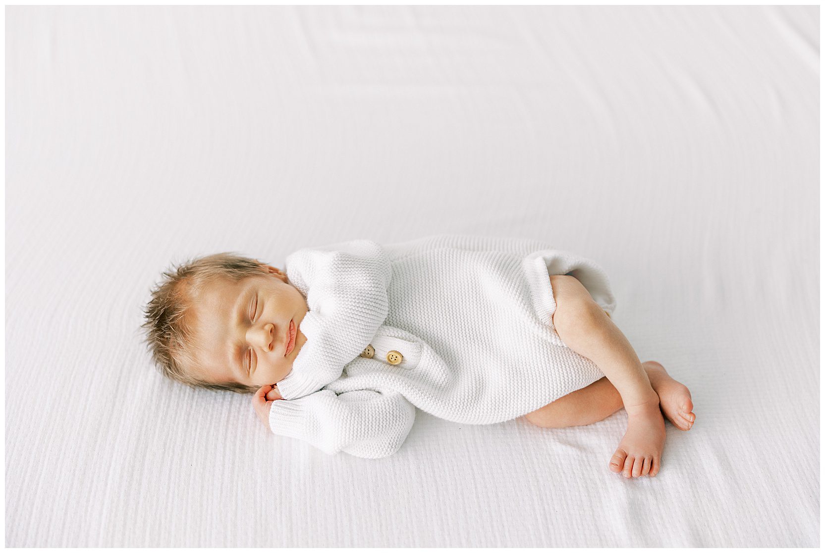 baby sleeping on bed at newborn session