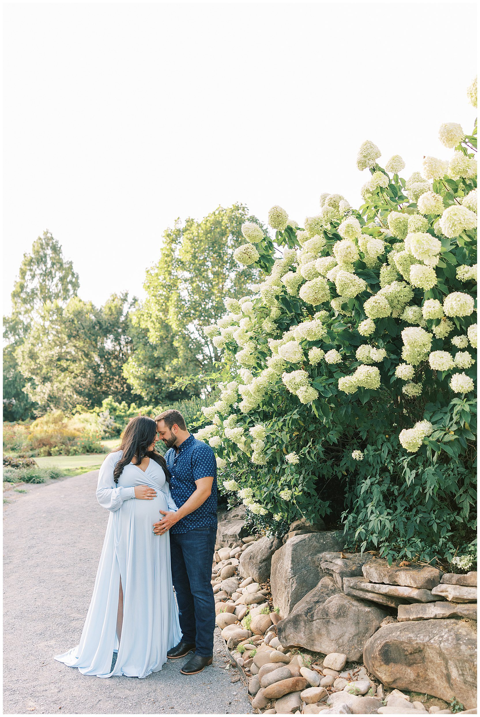 man and woman posing in front of hydrangea bush at ut gardens