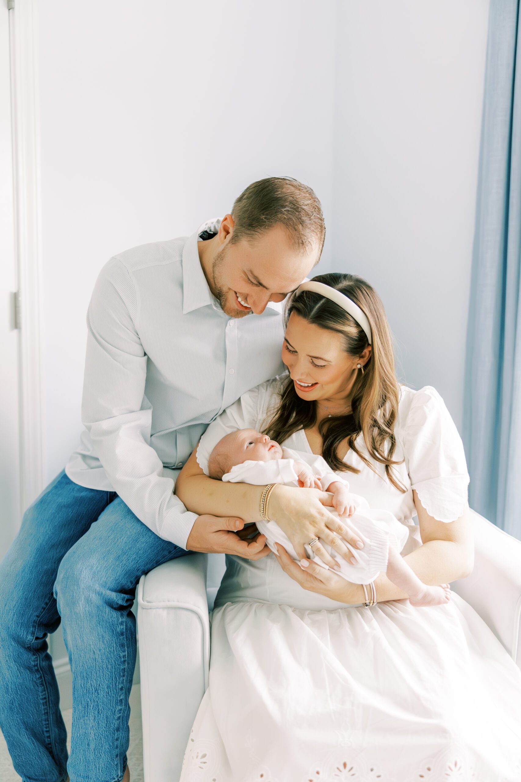 parents looking at baby- in home photos