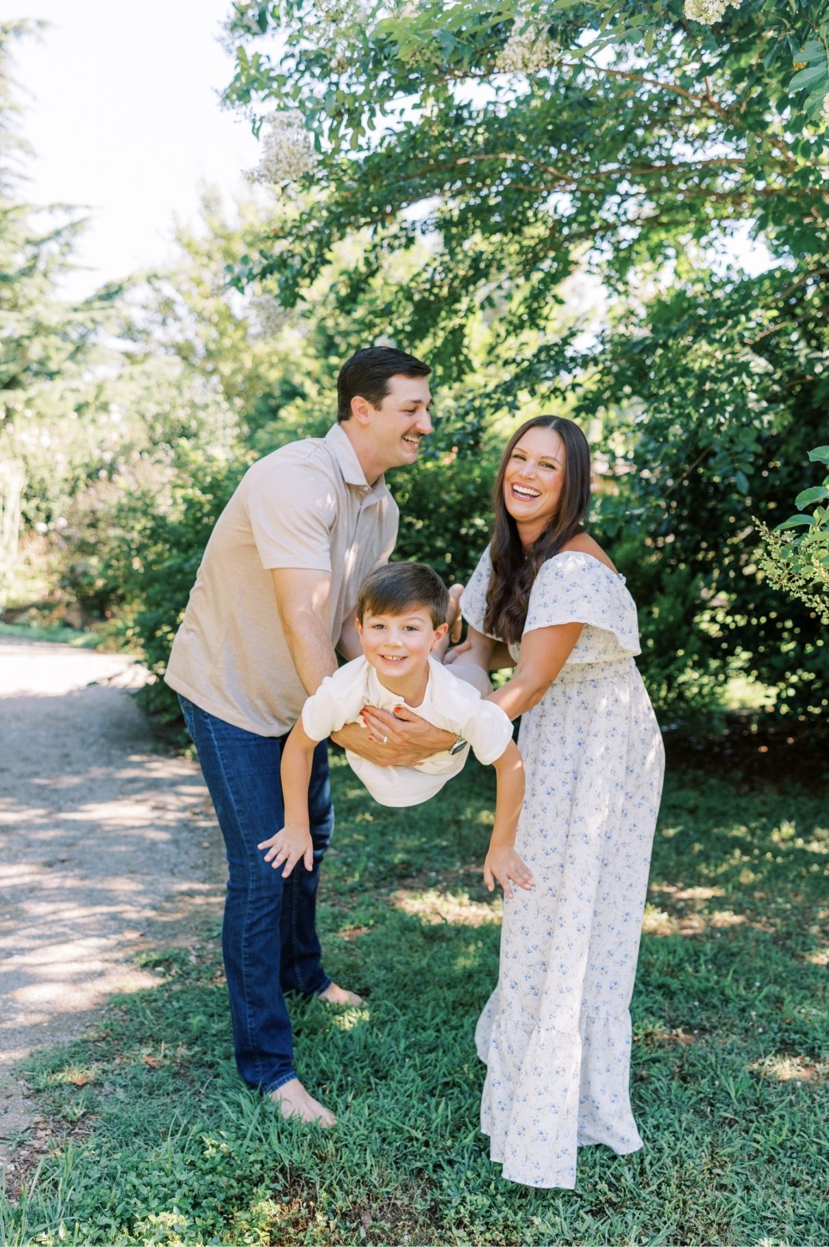 mom and dad holding son in arms flying