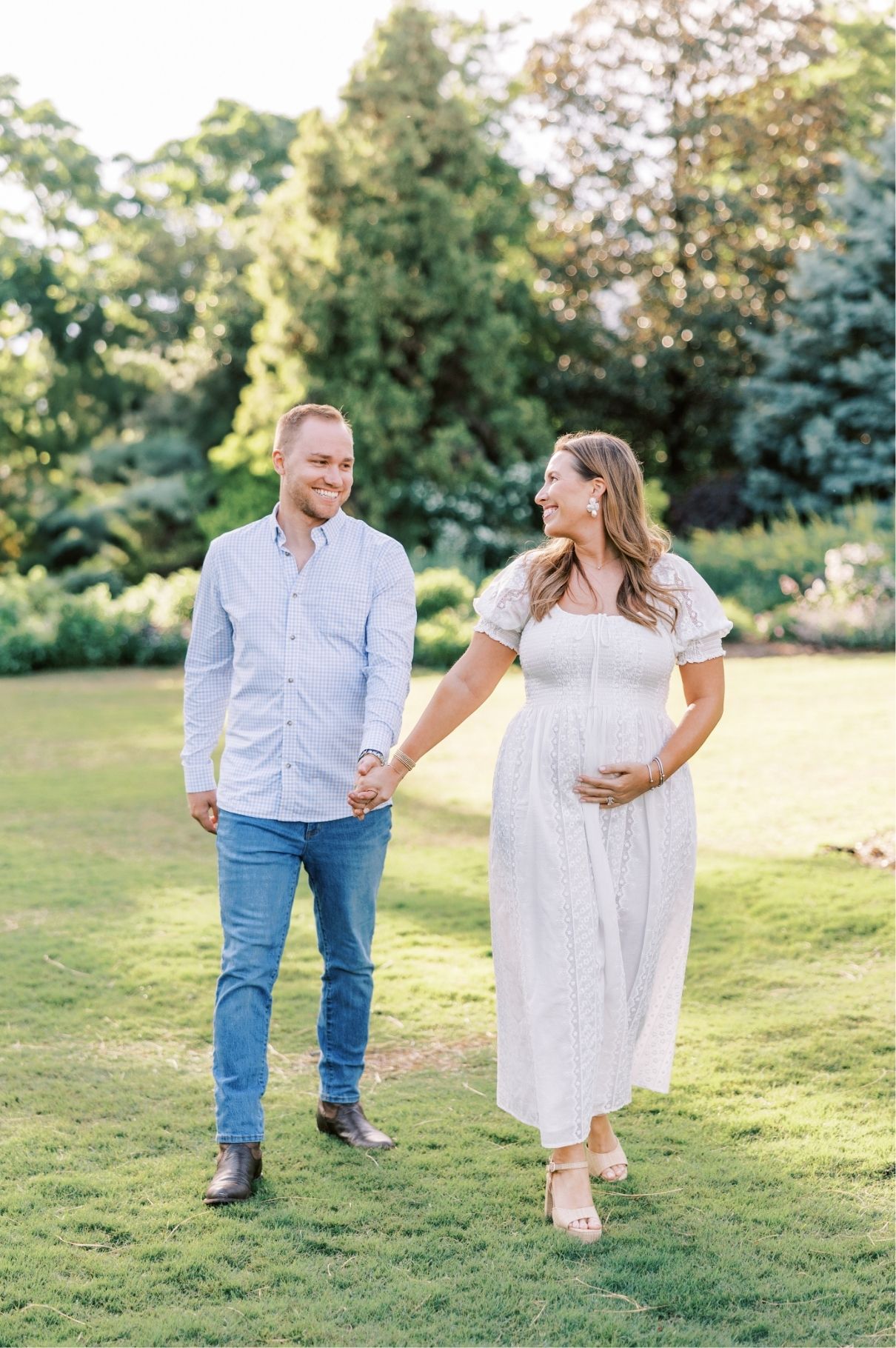 pregnant mom with husband holding hands walking