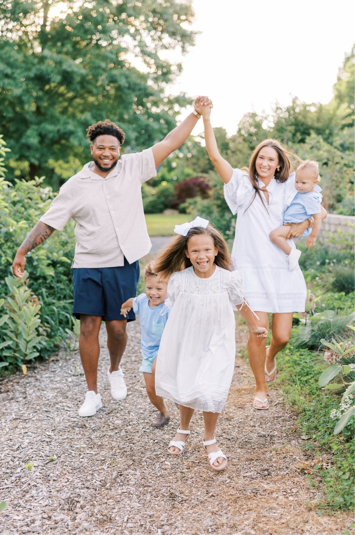 family picture; kids running and mom and dad holding hands high