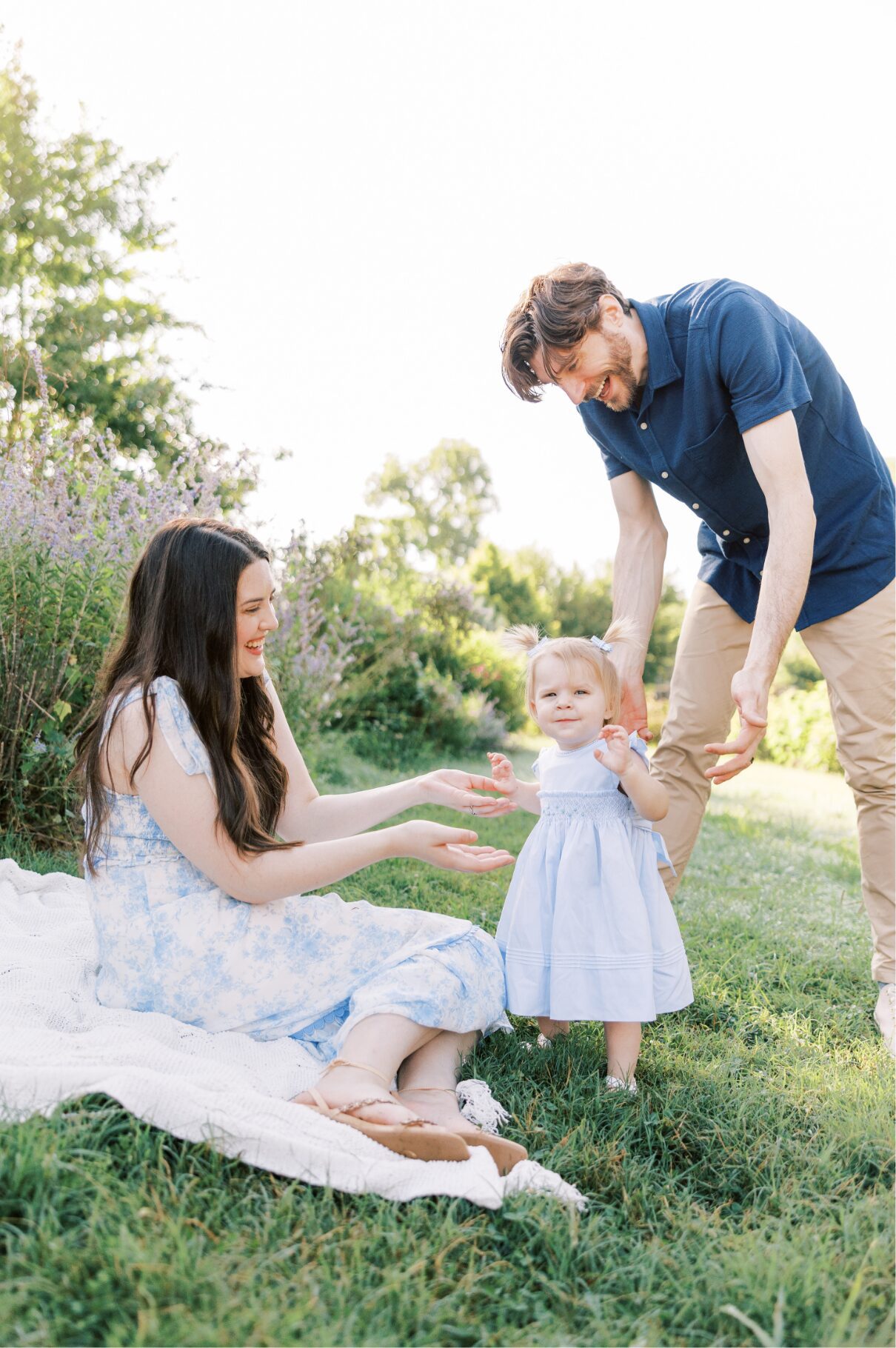 mom on blanket and dad holding little girls' hands