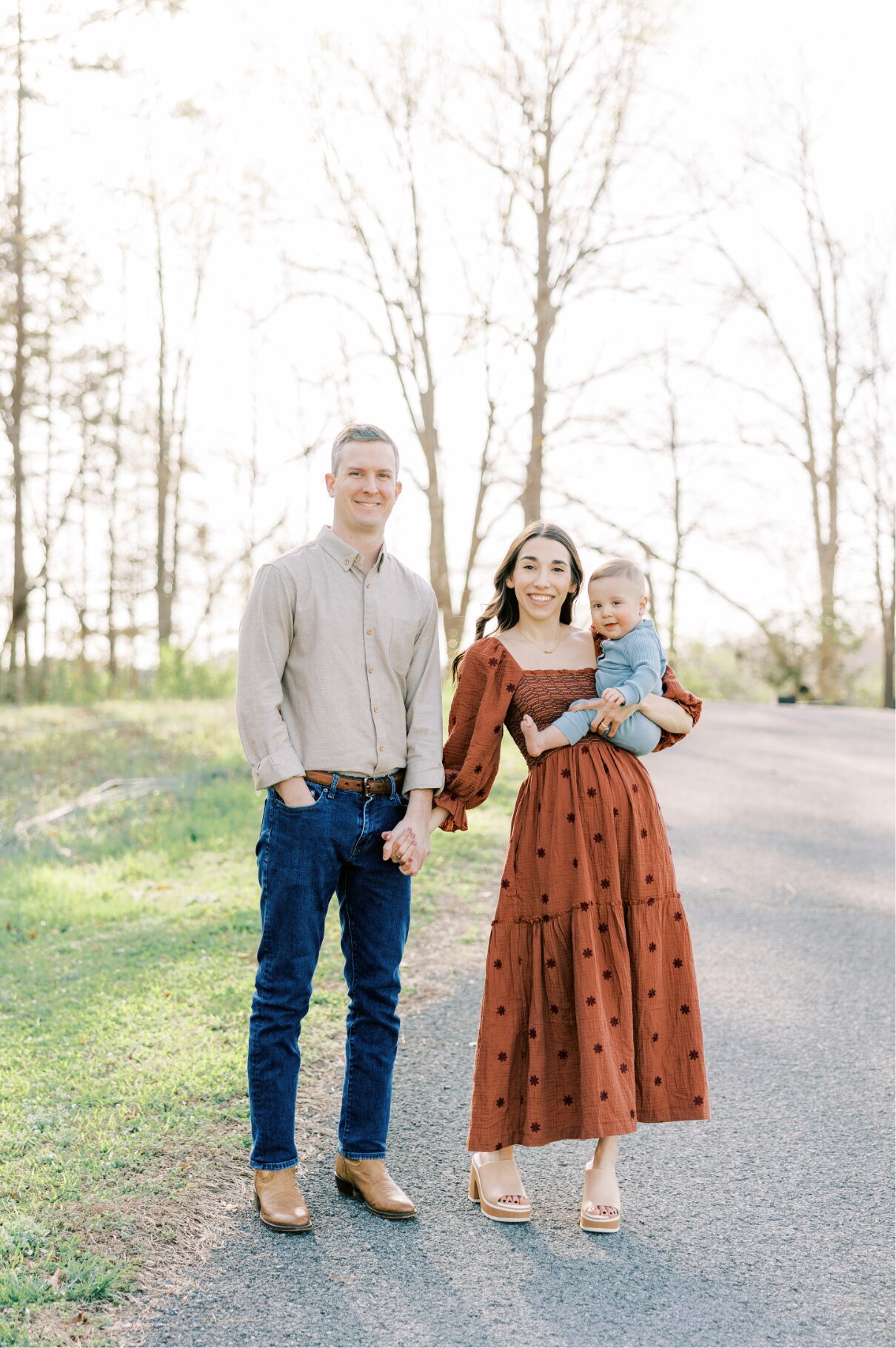 mom and dad holding hands looking at camera smiling