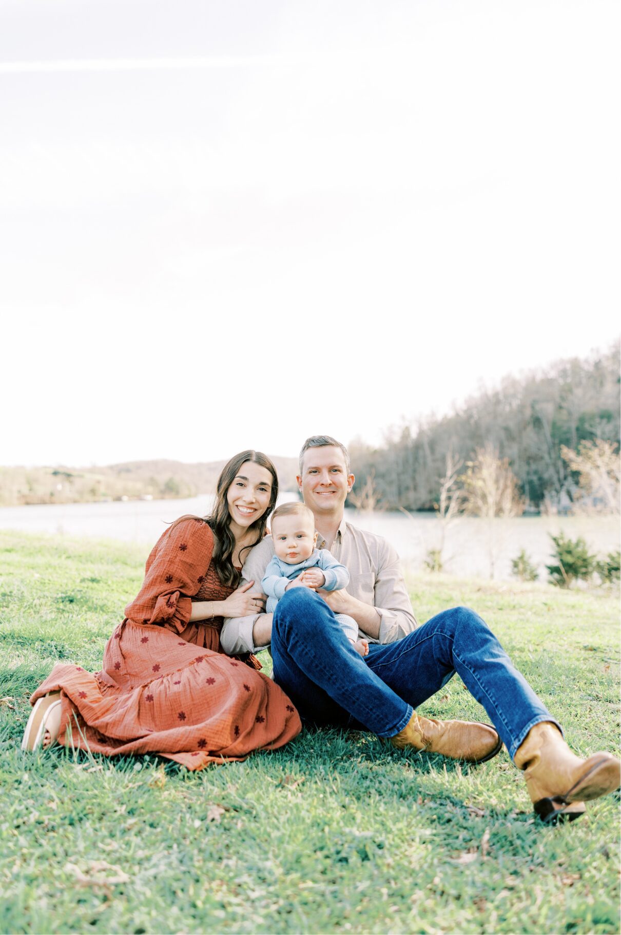 family sitting on ground smiling at camera