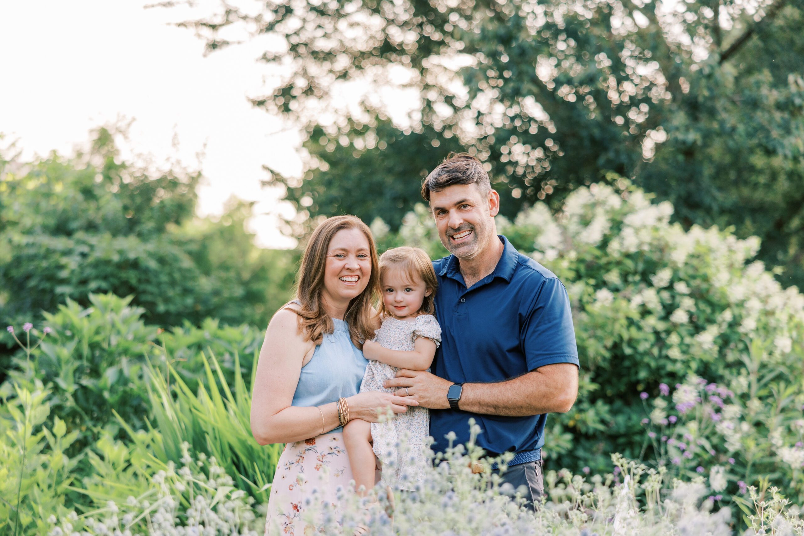 family smiling at camera in the flowers