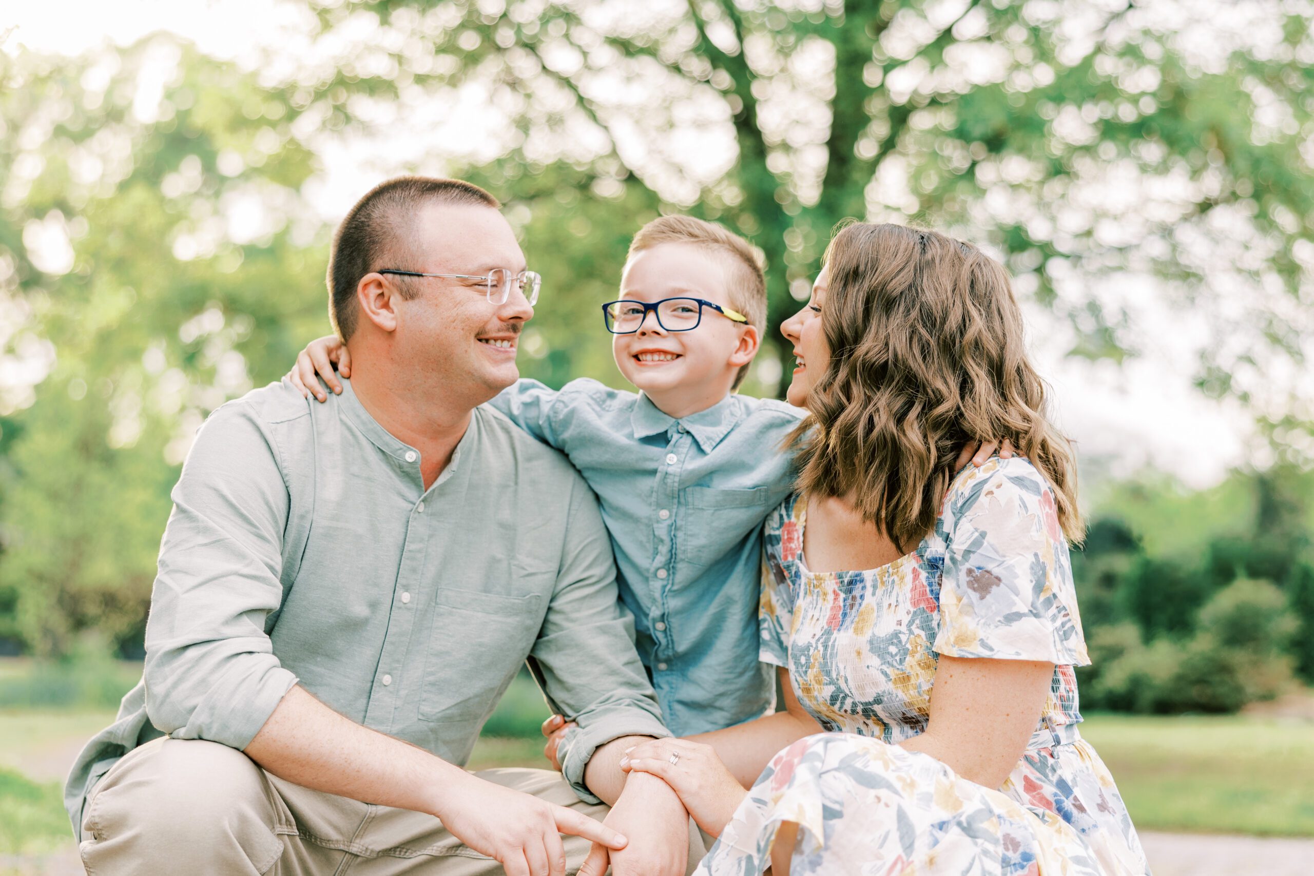 mom and dad smiling at son who is looking at camera